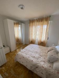 1 dormitorio con 1 cama con edredón blanco en Sole , Neve e Relax, en Clusone