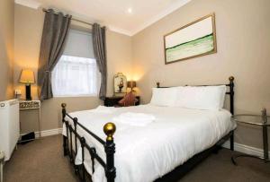 a bedroom with a large white bed and a window at Stones Throw in Scarborough