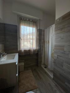 uma casa de banho com um lavatório e um chuveiro com uma janela em Sole , Neve e Relax em Clusone