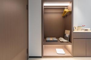 un placard avec une porte ouverte avec un clavier dessus dans l'établissement Atour X Hotel Guangzhou Avenue South Canton Fair-Free shuttle bus to Canton Fair, à Canton 55 autres photos