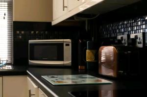a kitchen with a microwave and a counter top at Stones Throw in Scarborough +6 photos
