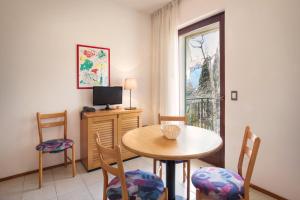 Residence il Cedro في مالسيسيني: غرفة طعام مع طاولة وكراسي ونافذة