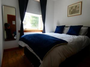 ein Schlafzimmer mit einem Bett mit blauen Kissen und einem Fenster in der Unterkunft Central 2-bed flat in Edinburgh in Edinburgh