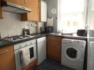 y cocina con fogones y lavadora. en Central 2-bed flat in Edinburgh, en Edimburgo