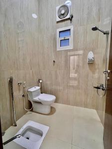 een badkamer met een toilet en een douche met een wastafel bij مارينا نجد للشقق الفندقية in Hotat bani tamim