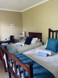 a room with two beds with blue pillows at Up The Hill Guesthouse in Kestell