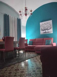 sala de estar con sofá rojo y sillas en Armony House, en Trecastagni