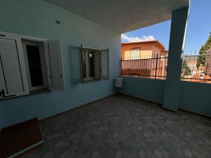 Habitación vacía con 2 ventanas y balcón. en PM 12 Via Umberto Primo Guest House, en Torpè