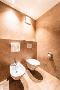 La salle de bains est pourvue de toilettes et d'un lavabo. dans l'établissement Naturhotel Leitlhof, à San Candido