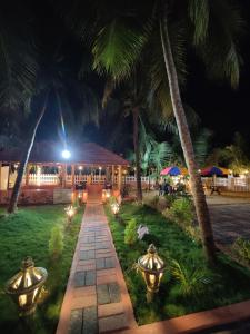 a walkway in front of a resort at night at HALF MOON HOMESTAY in Kalyānpur