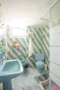 a bathroom with a blue toilet and a sink at Passiflora Vacation House in Nydri