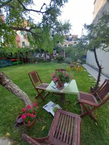 Passiflora Vacation House في نيدري: طاولة وكرسيين في ساحة بها ورد