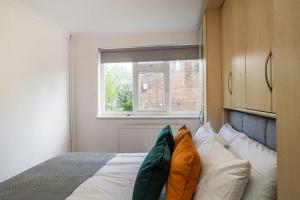 a bedroom with a bed with pillows and a window at Modern 3 Bedroom house in Finchley in Totteridge