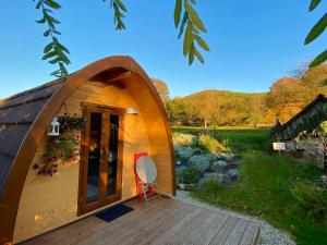 eine kleine Holzhütte mit einer Terrasse und einem roten Stuhl in der Unterkunft Hüttendorf Fränkische Schweiz in Pottenstein