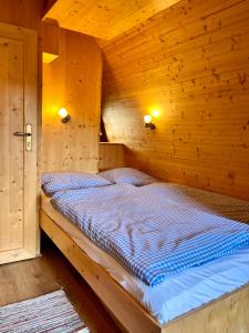 ein Schlafzimmer mit einem Bett in einem Holzzimmer in der Unterkunft Hüttendorf Fränkische Schweiz in Pottenstein