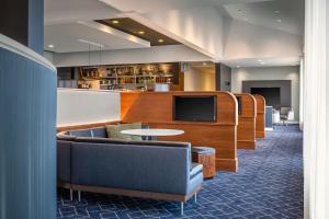 vestíbulo con sofás, TV y mesa en Courtyard by Marriott Minneapolis-St. Paul Airport, en Mendota Heights