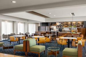 a restaurant with tables and chairs and a bar at Courtyard by Marriott Minneapolis-St. Paul Airport in Mendota Heights