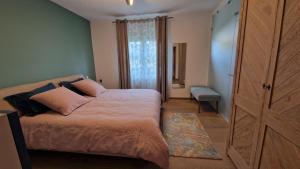 a bedroom with a bed and a large window at Le GM Maison de Vacances en Alsace in Mittelwihr