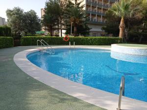 Playa de GandiaにあるTres Delfines Solo Familias Serviplayaの建物内に大きなプールがあり、
