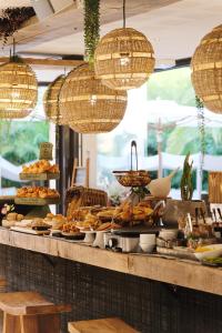 un buffet con pan, bollería y lámparas de araña en Hôtel Font Mourier, en Cogolin