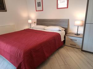 a bedroom with a bed with a red bedspread and two lamps at Your Comfort Home - Bologna in Bologna