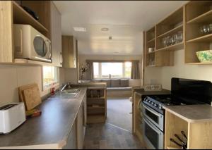 uma cozinha com armários de madeira e um forno com placa de fogão em Blue quary em Hastings
