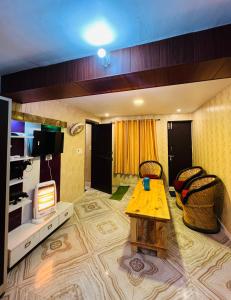 uma sala de estar com uma mesa e uma televisão em Exclusive Nagar Cottage em Mukteshwar