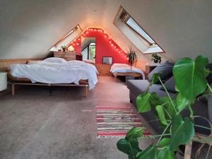 a room with two beds and a couch at Tuinkamer in charmante smidse in Zwalm
