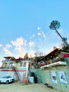 a house with a car parked in front of it at Exclusive Nagar Cottage in Mukteshwar