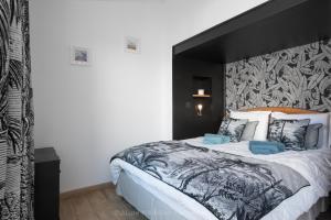 a bedroom with a large bed with a black headboard at Chez Paulette et Lucienne - Charme intimiste in Île dʼAix