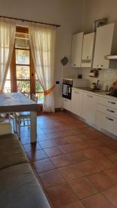 a kitchen with white cabinets and a table at Agriturismo Pastorelli in Osmate Lentate