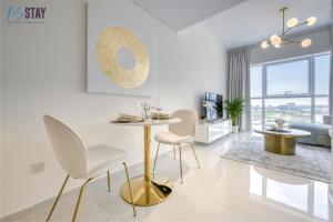 una sala de estar blanca con mesa y sillas en Elegant One Bedroom Apartment en Dubái