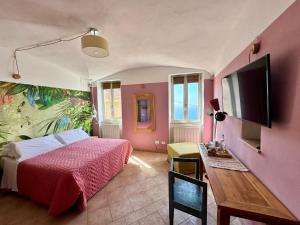 a bedroom with a bed and a desk and a tv at Le stanze sul mare in Borgio Verezzi