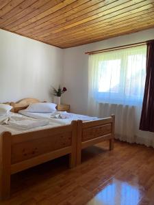 a bedroom with a large bed and a window at Casa de Vacanţă Vârtop in Vartop