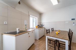 a kitchen with a table and a dining room at Sandy Bottoms Hostel in Albufeira