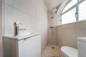 Baño blanco con lavabo y aseo en Sandy Bottoms Hostel, en Albufeira