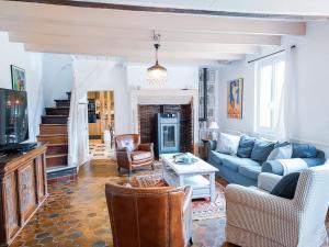 ein Wohnzimmer mit einem blauen Sofa und Stühlen in der Unterkunft Maison de charme - Piscine chauffée - 8 personnes in Danestal