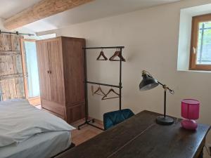 a bedroom with a desk with a lamp and a bed at Lou Boulugi in Aix-en-Provence