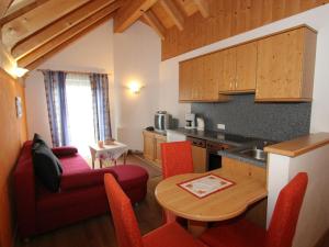 eine Küche mit einem Tisch und eine Küche mit roten Stühlen in der Unterkunft Spacious Apartment in L ngenfeld with Sauna in Huben