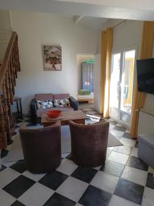 een woonkamer met een bank, een tafel en stoelen bij VILLA AVEC PISCINE A 400M DE LA PLAGE in Sanary-sur-Mer