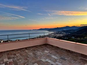 a balcony with a view of the ocean at sunset at Le stanze sul mare in Borgio Verezzi