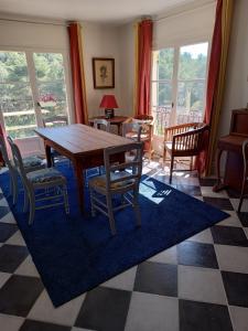 een eetkamer met een houten tafel en stoelen bij VILLA AVEC PISCINE A 400M DE LA PLAGE in Sanary-sur-Mer