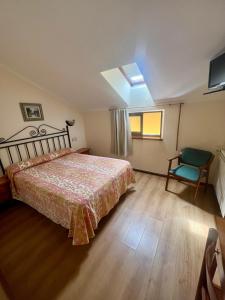 a bedroom with a bed and a window and a chair at Hotel Gavitu in Celorio