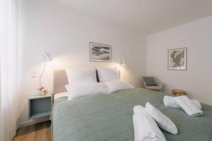 a bedroom with a large green bed with white pillows at Central Apartment near Opera - 1 Room in Bayreuth