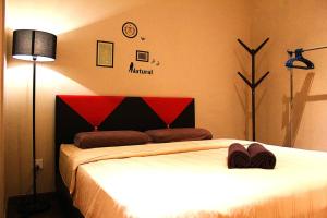 1 Schlafzimmer mit 2 Betten mit einem roten und schwarzen Kopfteil in der Unterkunft Riverson SOHO Kota Kinabalu in Kota Kinabalu