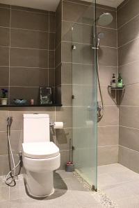 ein Bad mit einem WC und einer Glasdusche in der Unterkunft Riverson SOHO Kota Kinabalu in Kota Kinabalu