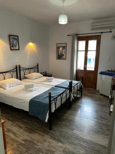 een slaapkamer met een groot bed in een kamer bij KIRIKOS ROOMS in Sifnos