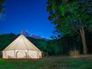 ブイヨンにあるLodg'ing Nature Camp Ardennes NEW 2024の木の入った野原の白いテント