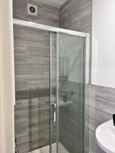 een glazen douche in een badkamer met een wastafel bij Deluxe Size - Entire Studio in Seven Kings