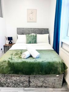 een slaapkamer met een bed met twee handdoeken erop bij Deluxe Size - Entire Studio in Seven Kings